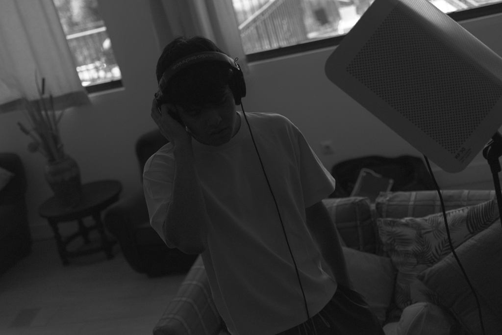 Artista con auriculares en el salón, en blanco y negro